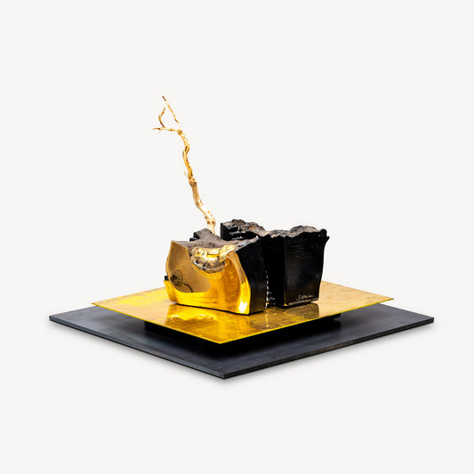 Decorative art glass piece called Ashes and Diamond by Bertil Vallien with black and gold elements on a white background