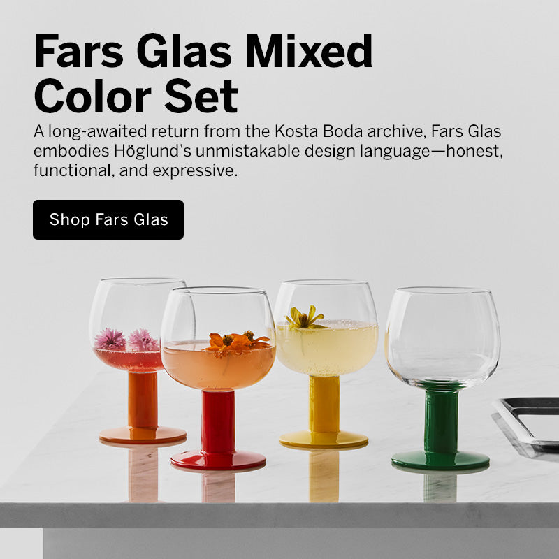 Mobile version image of four Fars Glas mixed-color stemware glasses with orange, red, yellow, and green bases, shown on a white surface against a light gray background with promotional text; 'A long-awaited return from the Kosta Boda archive, Fars Glas embodies Höglund’s unmistakable design language—honest, functional, and expressive.'