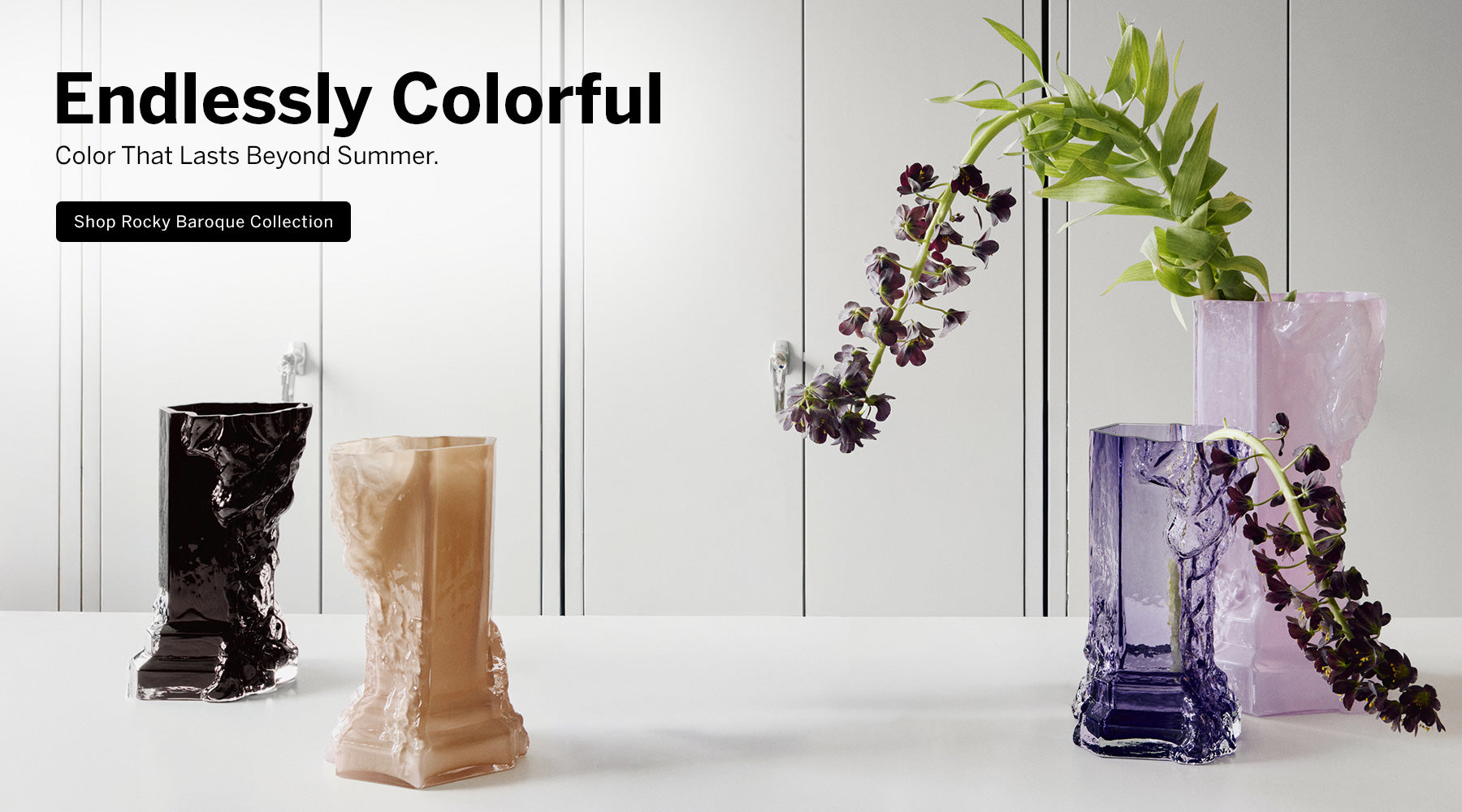 Rocky Baroque Collection black, dusty pink, violet and cool pink vases on white surface with neutral backdrop with text describing 